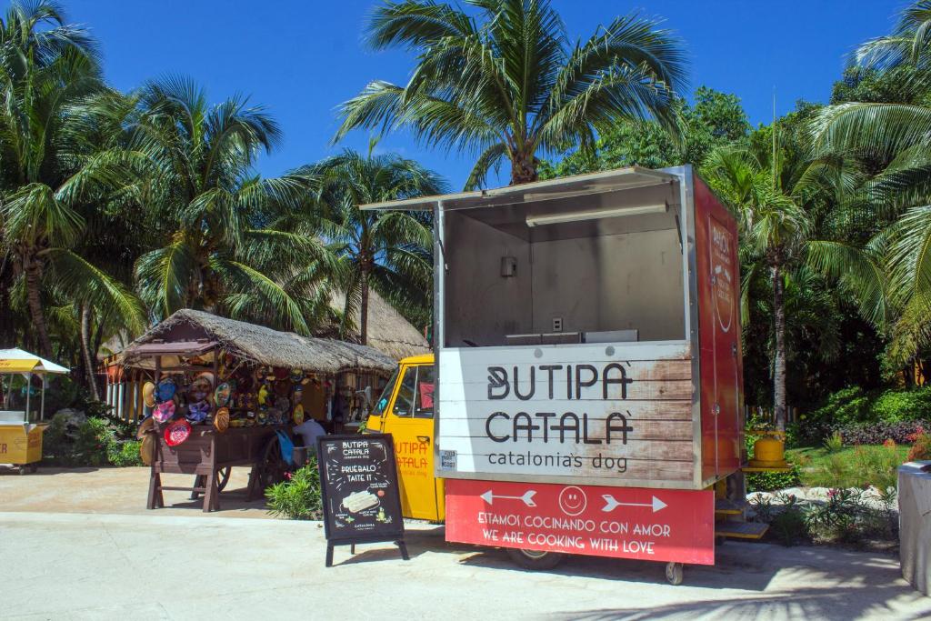 Ielu ēdienu stends ar nosaukumu "Dutipa Català" piedāvā ēdienus Katalonijas stilā. Apkārt ir tropisko palmu ainava, radot relaksējošu atmosfēru.