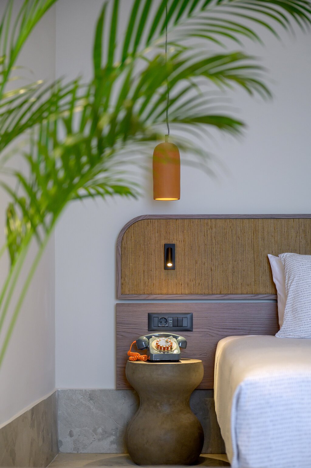 Stilīgs INNSiDE by Meliá Elounda numura interjers ar retro telefonu un dabas elementiem