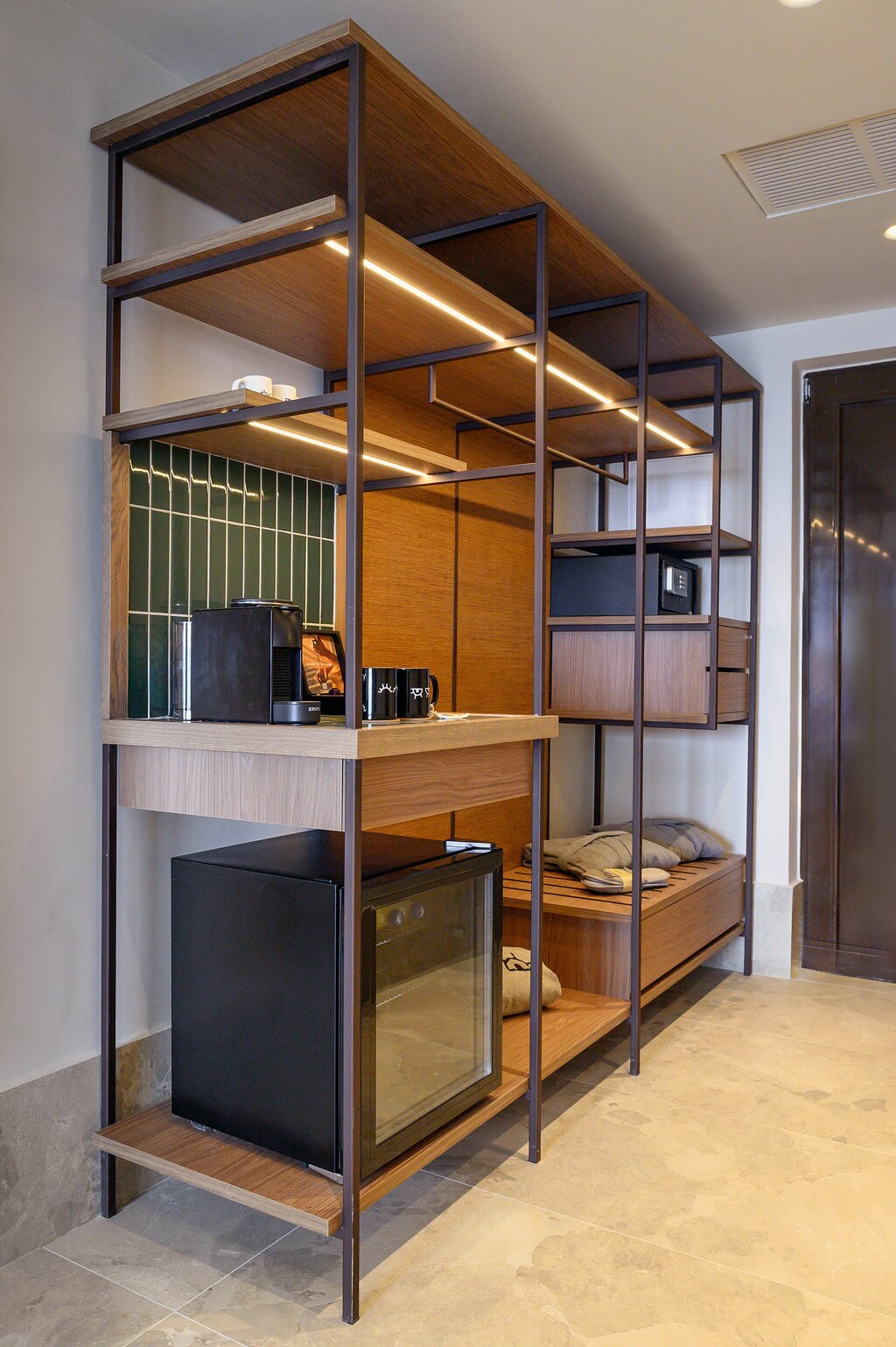 Moderns minibārs un atvērta garderobe INNSiDE by Meliá Elounda numurā.