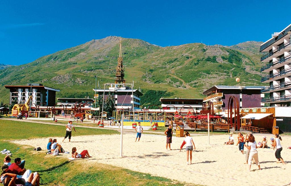 Atpūtas zona ar pludmales volejbola laukumiem un viesnīcām, ieskauta zaļām kalnu ainavām un skaidrām debesīm. Ideāla vieta atpūtai un sportiskām aktivitātēm.