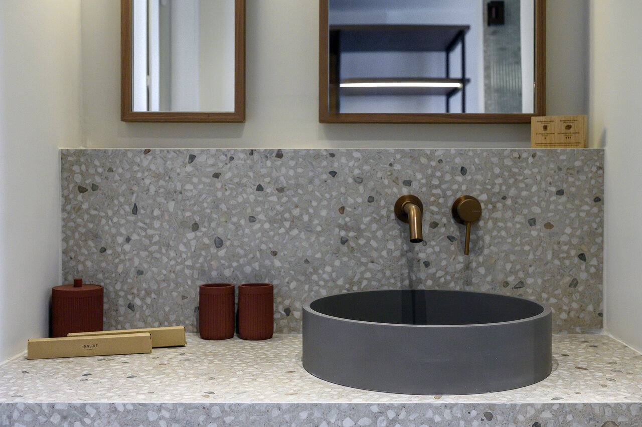 Mūsdienīga vannas istaba ar terrazzo apdari un bronzas elementiem INNSiDE by Meliá Elounda numurā