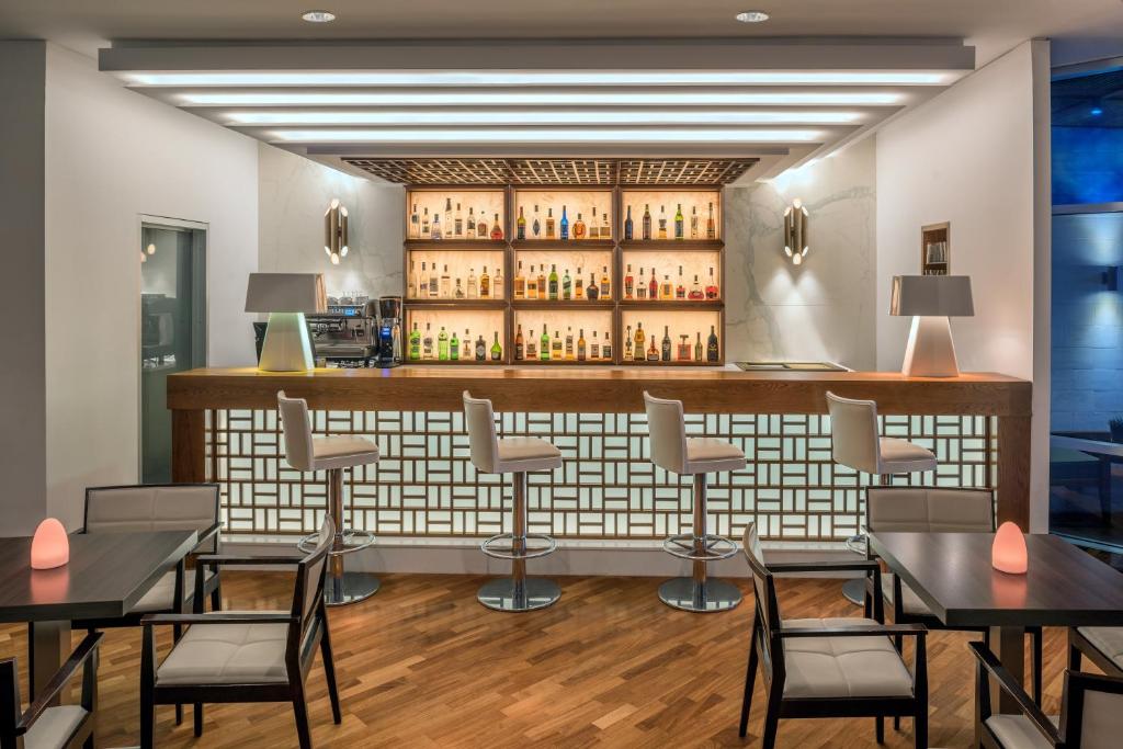 Moderns bārs ar elegantu interjeru, kas ietver stilīgas bāra krēsli un plašu alkoholisko dzērienu izvēli uz apgaismotas plauktu. Koka grīda un minimālistiskais dizains rada patīkamu atmosfēru.