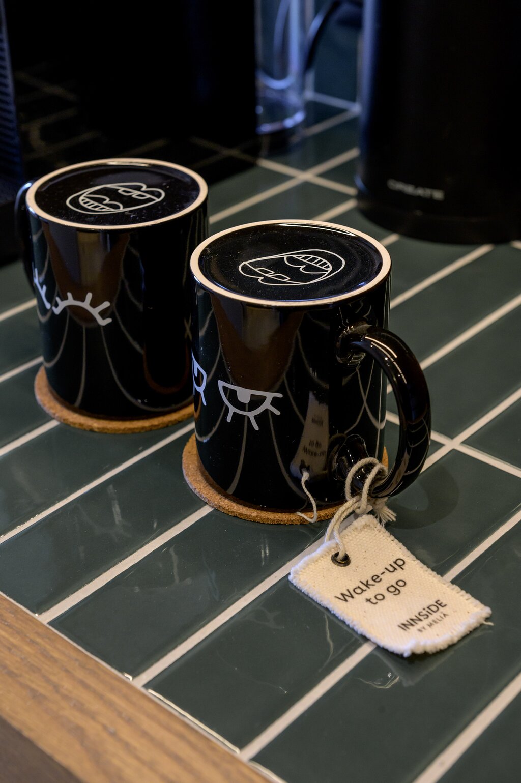 Melnas kafijas krūzes ar dizainu un birku INNSiDE by Meliá Elounda numurā
