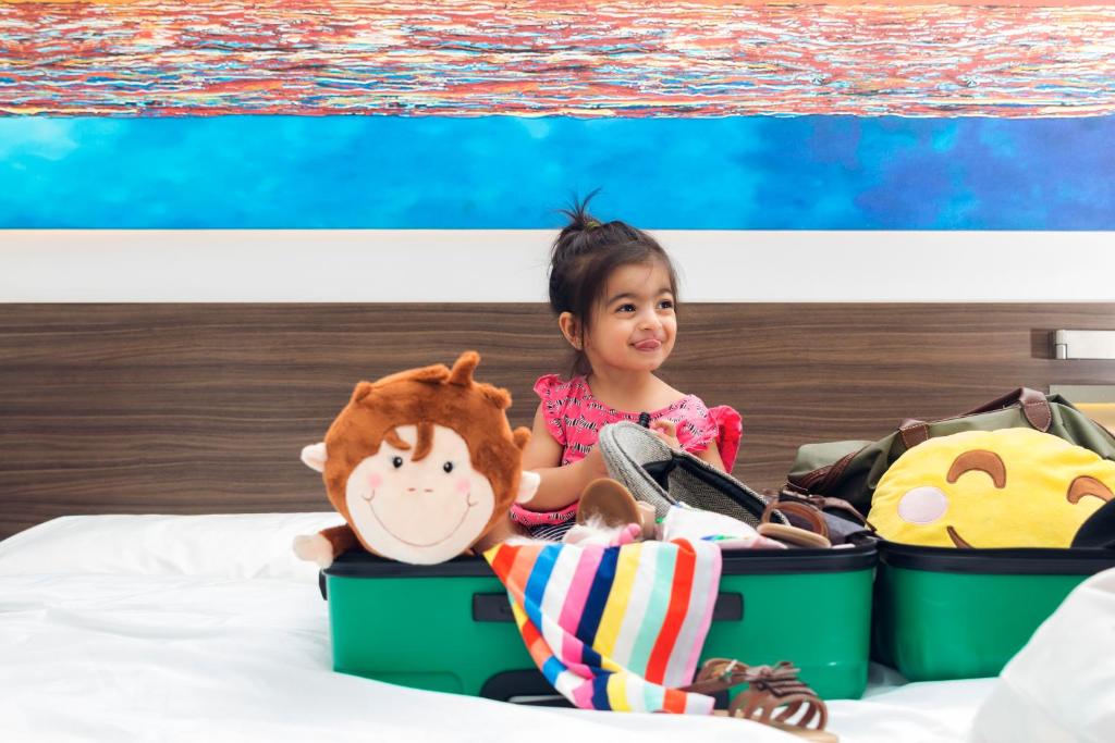 Bērns Citymax al Barsha numurā ar koferiem un rotaļlietām.