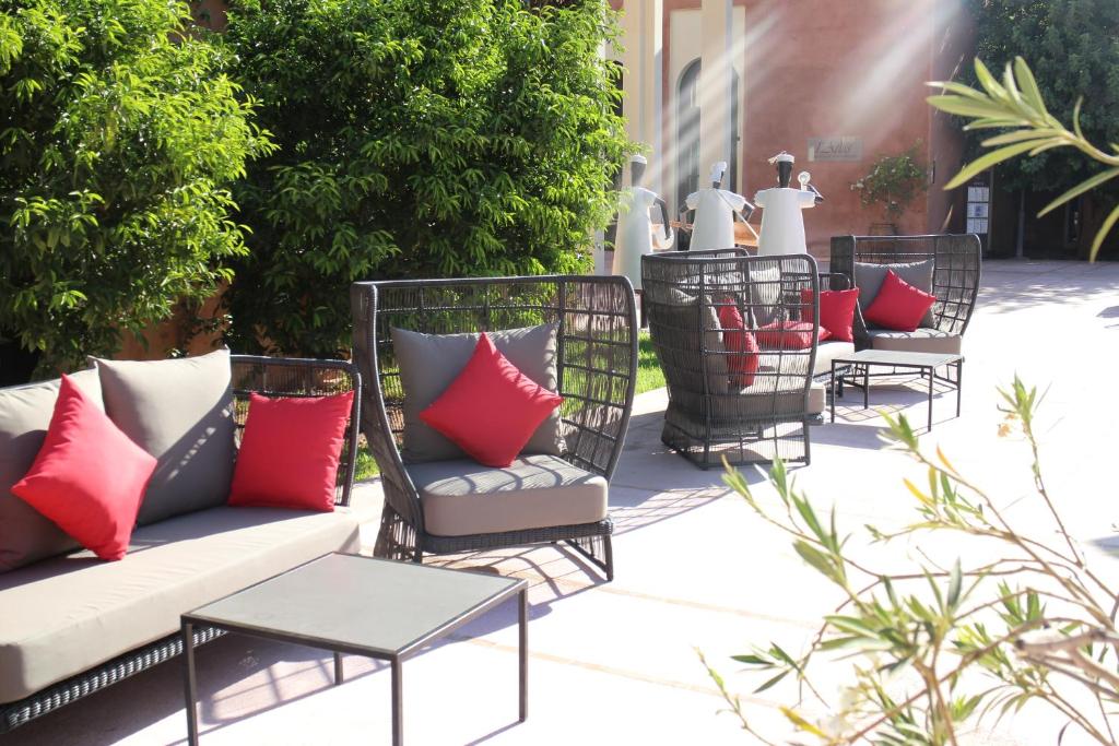 Dārza istabas ar ērtām mēbelēm un spilveniem, kas rada relaksējošu atmosfēru. Zaļi augi fonā papildina telpas estētiku.