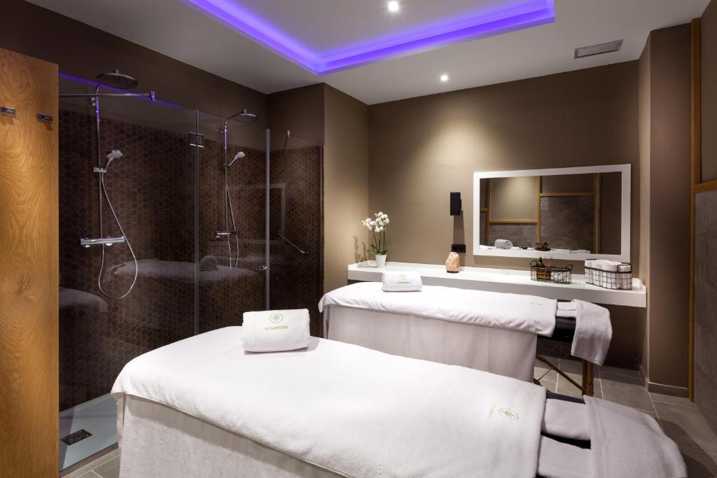 Spa telpa ar masāžas galdiem, stikla dušām un mūsdienīgu apgaismojumu. Ideāla vieta relaksācijai un labsajūtai.