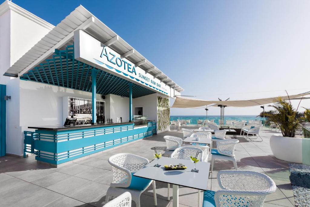 Elegants jumta bārs ar skatu uz jūru, modernām mēbelēm un atvērtu terasi, kurā tiek pasniegti kokteiļi un uzkodas. Ideāla vieta relaksācijai un saulrieta baudīšanai.