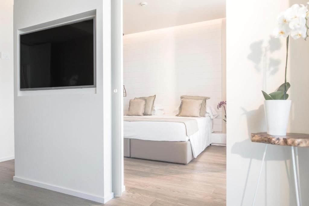 Mūsdienīgs viesnīcas numurs ar gultu, plakanā ekrāna televizoru un elegantu augu dekoru. Interjers ir gaišs un minimālistisks, radot patīkamu atmosfēru.