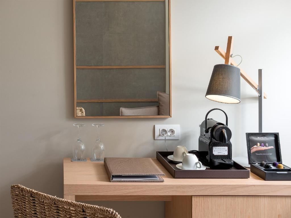 Moderns darba stūris ar koka galdu, lampu un kafijas automātu, kas papildināts ar elegantiem traukiem un dekoratīvu spoguli. Ideāls interjers relaksējošai atmosfērai.