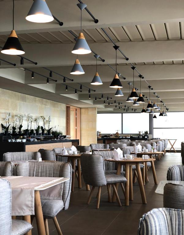 Mūsdienīgs restorāna interjers ar stilīgām lampām un elegantiem galdiem. Gaišas krāsas un plašas telpas rada patīkamu atmosfēru.