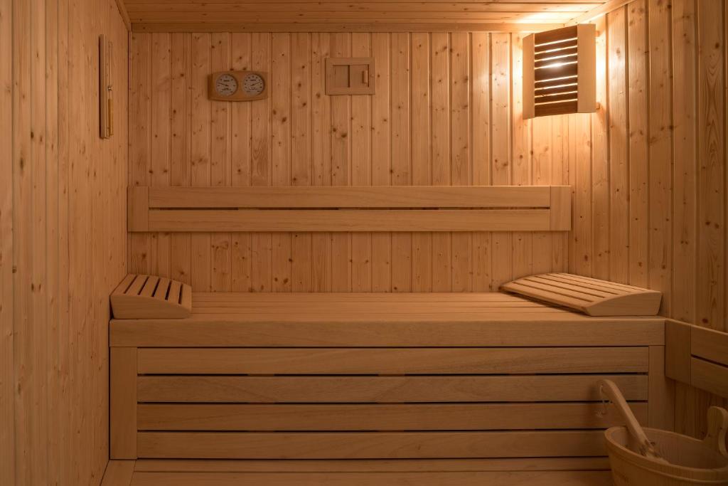 Koka saunas iekšējā telpa ar gultu un koka aksesuāriem, radot mierīgu un relaksējošu atmosfēru. Sienas apdare ir no koka dēļiem, un telpā ir iekārtoti gaismas avoti.