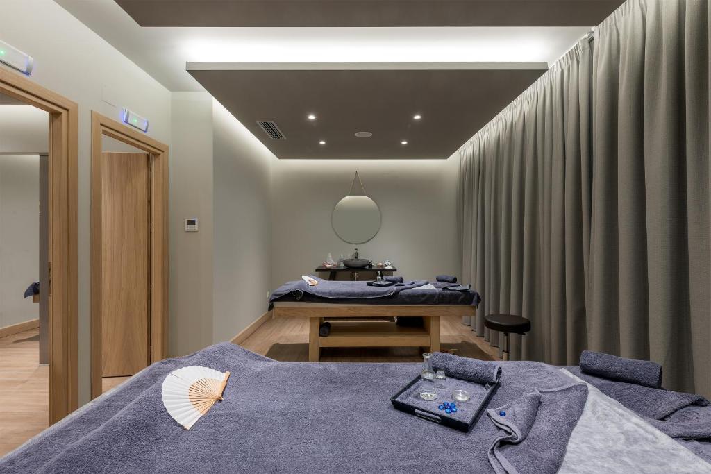 Mūsdienīgs spa telpas interjers ar masāžas galdiem, relaksējošām gaismām un dekoratīvām detaļām. Telpa ir izveidota, lai sniegtu mierīgu un relaksējošu atmosfēru.