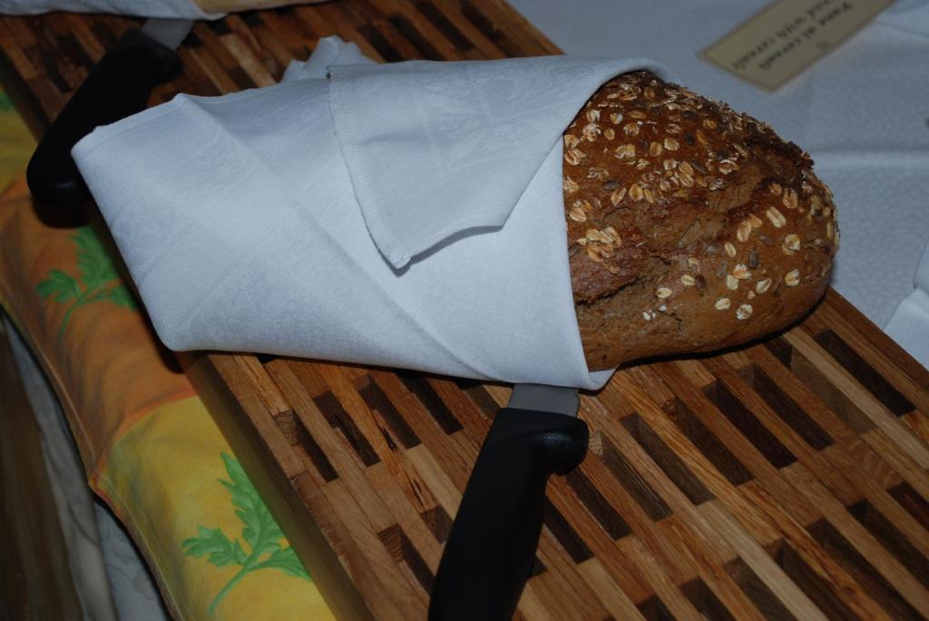 Maizes kukulis, kas ietīts baltā salvetē, atrodas uz koka griešanas dēļa kopā ar nazi. Izskatās apetelīgi un svaigi.