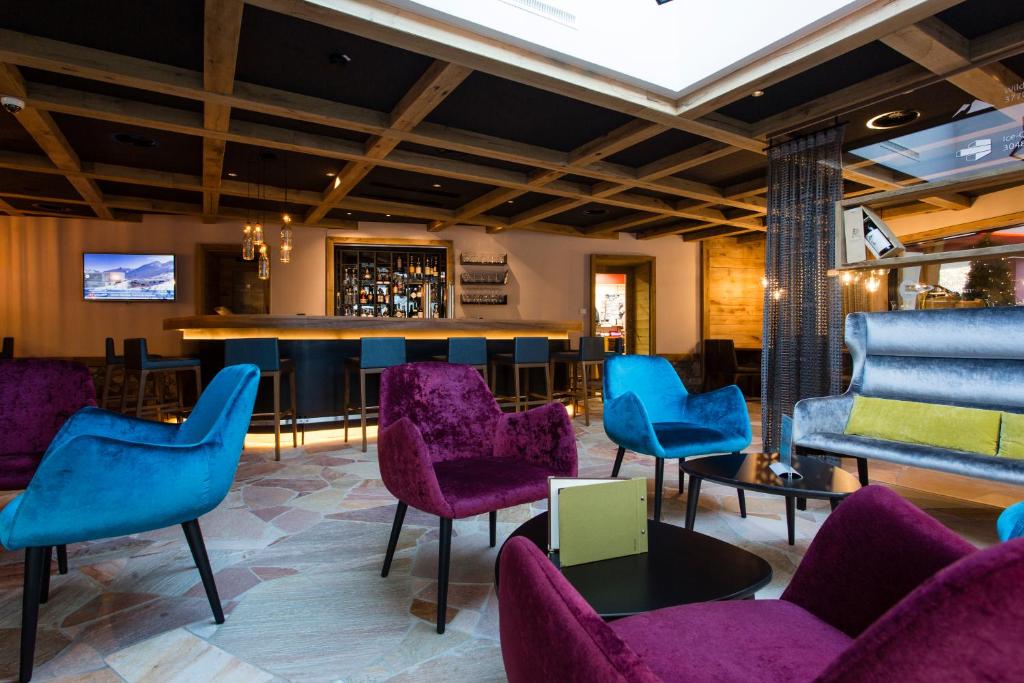 Mūsdienīgs bārs ar krāsainām ērtām krēslām un stilīgu interjeru, kas ietver koka griestus un modernu apgaismojumu. Ideāla vieta relaksācijai un sociālajiem pasākumiem.