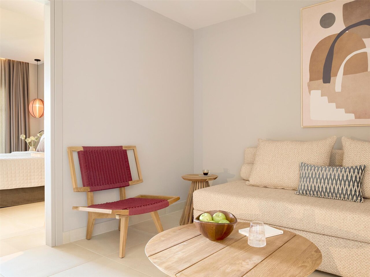 MarBella viesnīcas numura interjers ar ērtu atpūtas zonu un guļamistabas skatu.