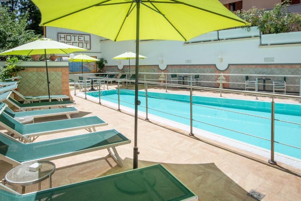 Baseins ar saulessargiem viesnīcas teritorijā, kur viesi var atpūsties uz sauļošanās krēsliem, baudot atpūtu un relaksāciju.