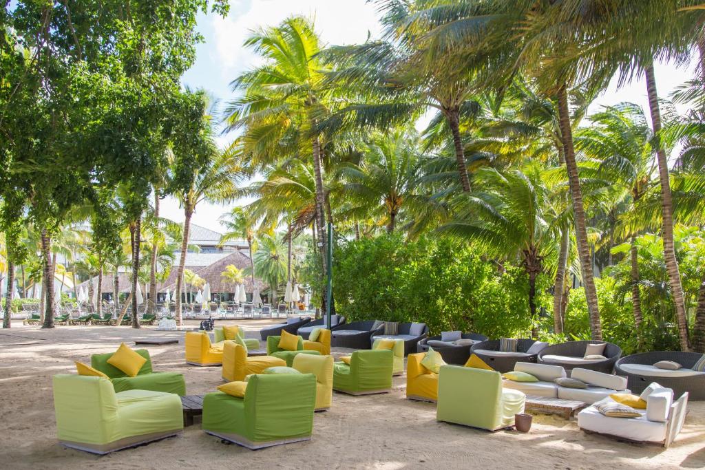 Tropiskā pludmales zona ar ērtām krēsliem un palmām. Krāsaini dīvāni un sēdvietas nodrošina relaksējošu atmosfēru.