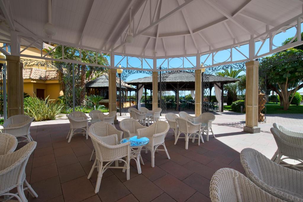 Āra terase Hotel IPV Palace & Spa ar pītām mēbelēm un skatu uz dārzu.