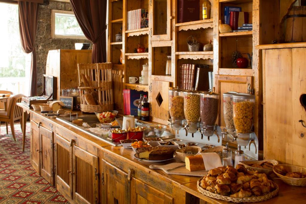 Koka bufete ar dažādām brokastu uzkodām, tostarp konditorejas izstrādājumiem, augļiem un graudaugiem, iekārtota mājīgā vidē. Idealizēta atmosfēra relaksētām brokastīm.