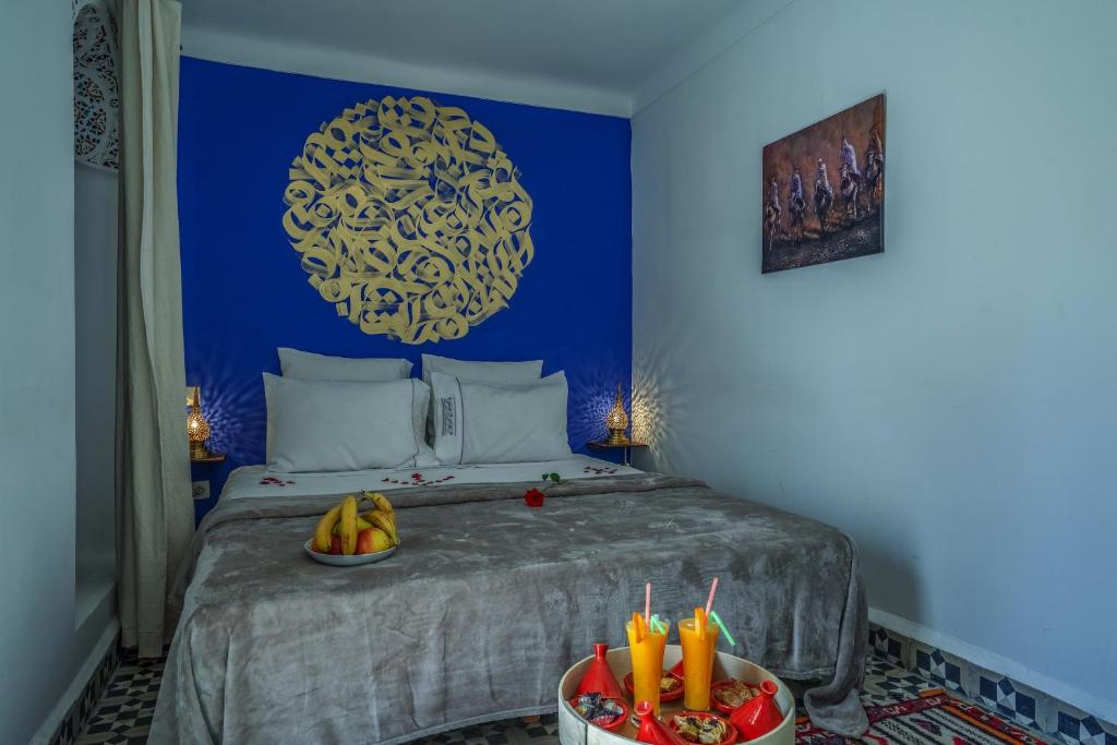 Mūsdienīgs guļamistabas interjers ar zilu sienu un dekoratīvu elementu, kas pievieno mājīgumu, kā arī augļu trauks un dzērienu servēšana. Ideāla vieta relaksācijai un atpūtai.