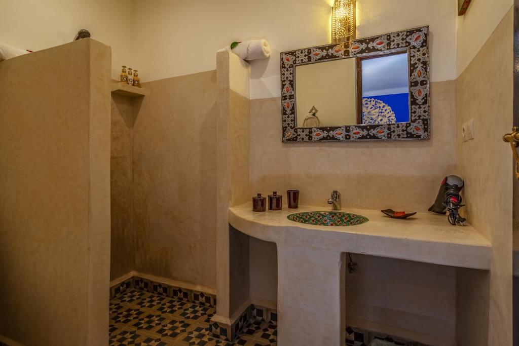 Stilīga vannas istaba ar dabīgām krāsām, paklāju un dekoratīvu spoguli, radot relaksējošu atmosfēru. Svaigas vannas piederumi un mākslas elementi papildina telpas estētiku.