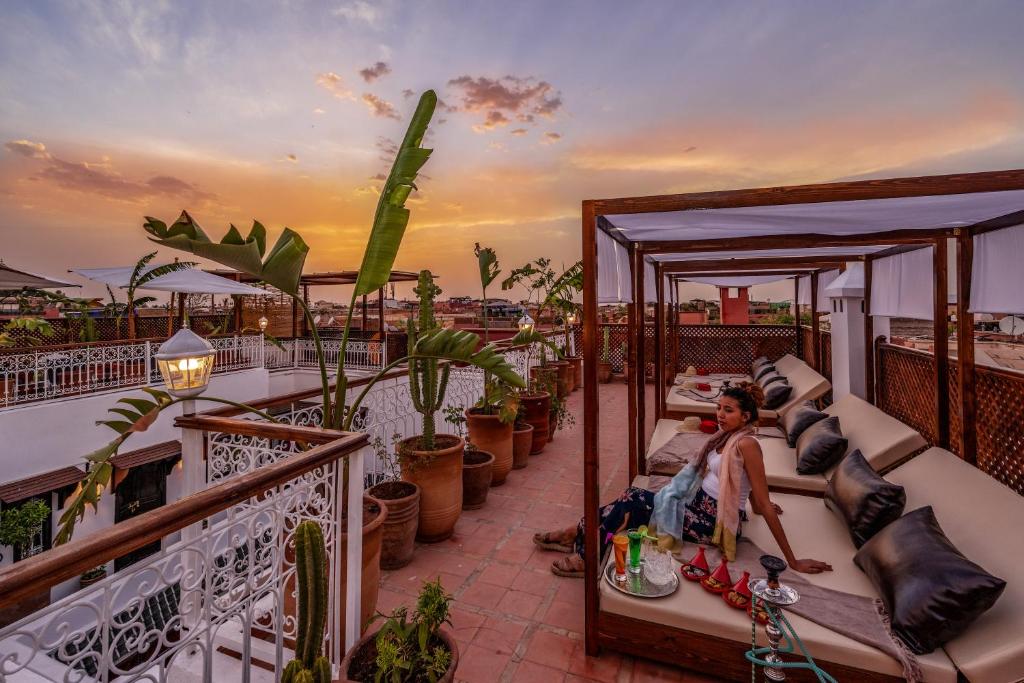 Terases skats ar saulrietu, kurā redzami ērti sēdekļi un augi, radot relaksējošu atmosfēru. Ideāla vieta atpūtai un baudīšanai.