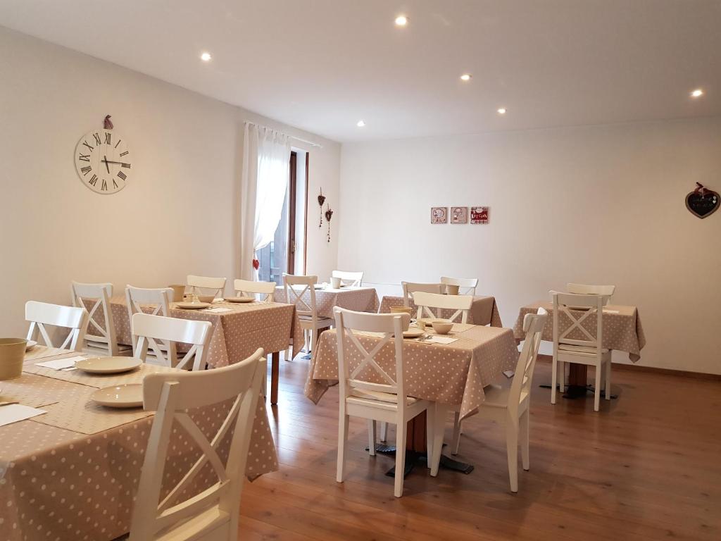 Gaiša un mājīga restorāna telpa ar baltiem galdiem un brūnu grīdu, dekorēta ar polka punktu galdautiem. Logā ieplūst dabiska gaisma, radot patīkamu atmosfēru.