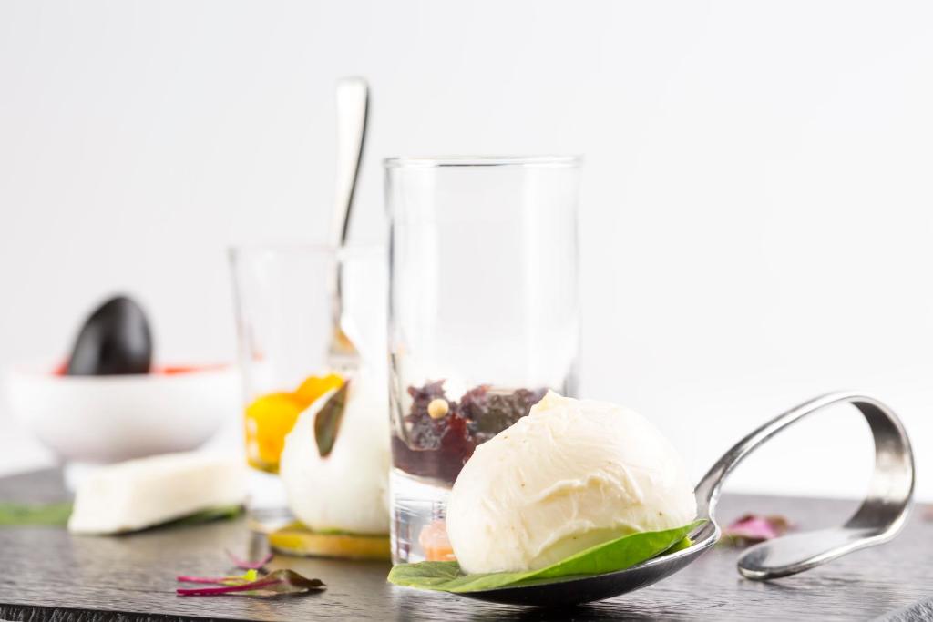 Gards deserts, kas sastāv no krēmveida saldējuma, augļu un riekstu sastāvdaļām, pasniegts uz melnas koka dēļa.