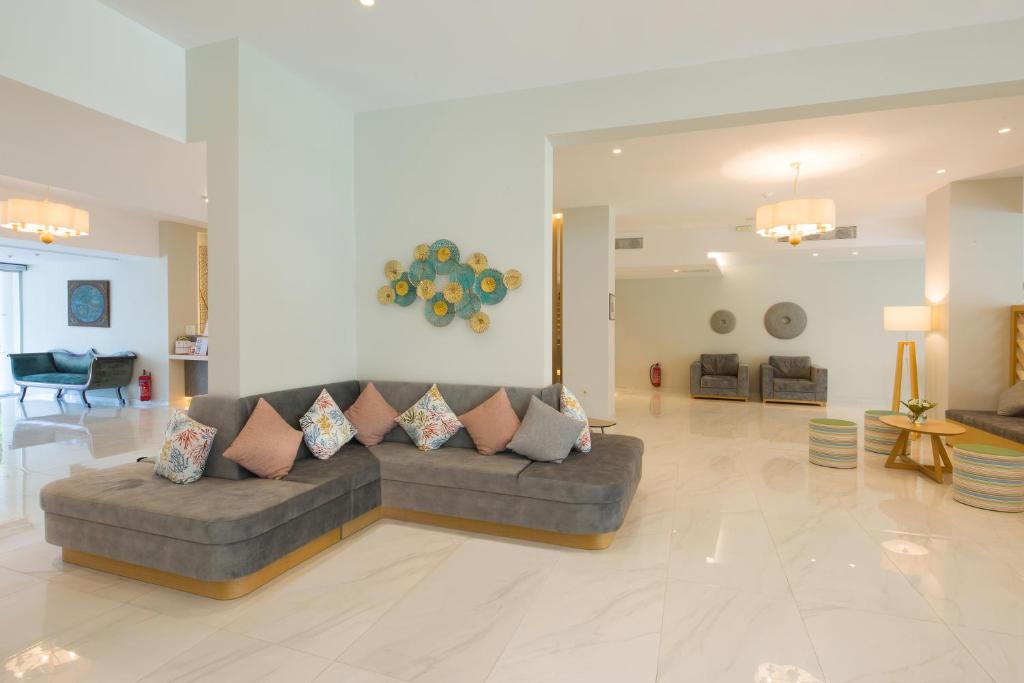 Mūsdienīgs viesnīcas vestibilis ar elegantu dīvānu, dekoratīvām spilveniem un stilīgiem sēdvietām. Gaismas un krāsas rada siltu un laipnu atmosfēru.