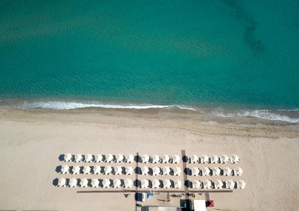 Pludmales skats ar saulessargiem un kristāldzidru ūdeni, kas veido mierīgu atmosfēru. Ideāla vieta atpūtai un relaksācijai.