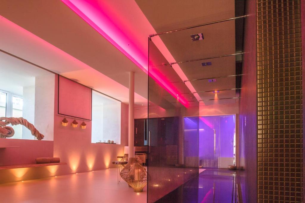 Mūsdienīgs interjers ar rozā un purpura apgaismojumu, kas rada relaksējošu atmosfēru. Telpa ir izveidota ar elegantiem elementiem un minimālistisku dizainu.