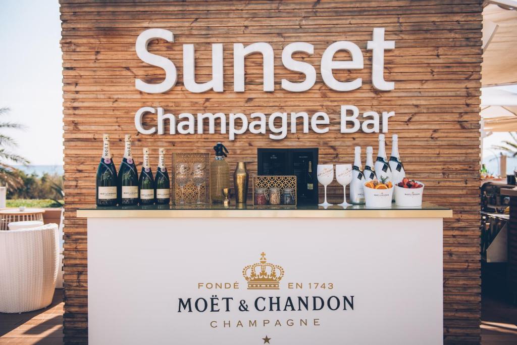 Šampanieša bārs "Sunset" ar Moët & Chandon šampanieša pudelēm un augļu groziem, radot elegantu atmosfēru.