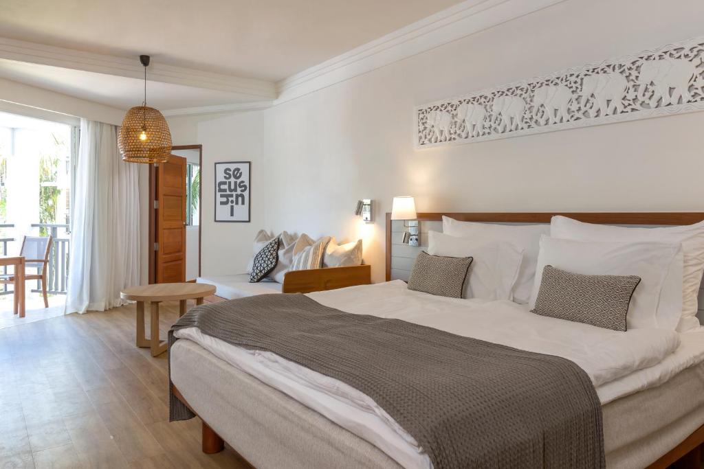 Moderns viesnīcas numurs ar ērtu gultu, gaišām krāsām un dabiskiem materiāliem, kas rada relaksējošu atmosfēru. Numurā ir pieejams dīvāns un balkons, nodrošinot ērtu atpūtu.