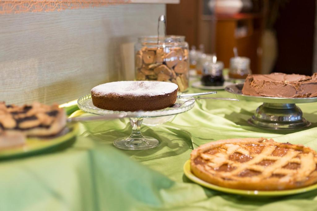 Deserts uz galda, tostarp šokolādes kūka, pīrāgs ar ogām un cepumi. Svaigi cepti gardumi uz zaļas galda drānas.