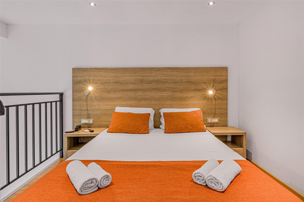 Panorama Village Hotel numura interjers ar divguļamo gultu un oranžiem akcentiem