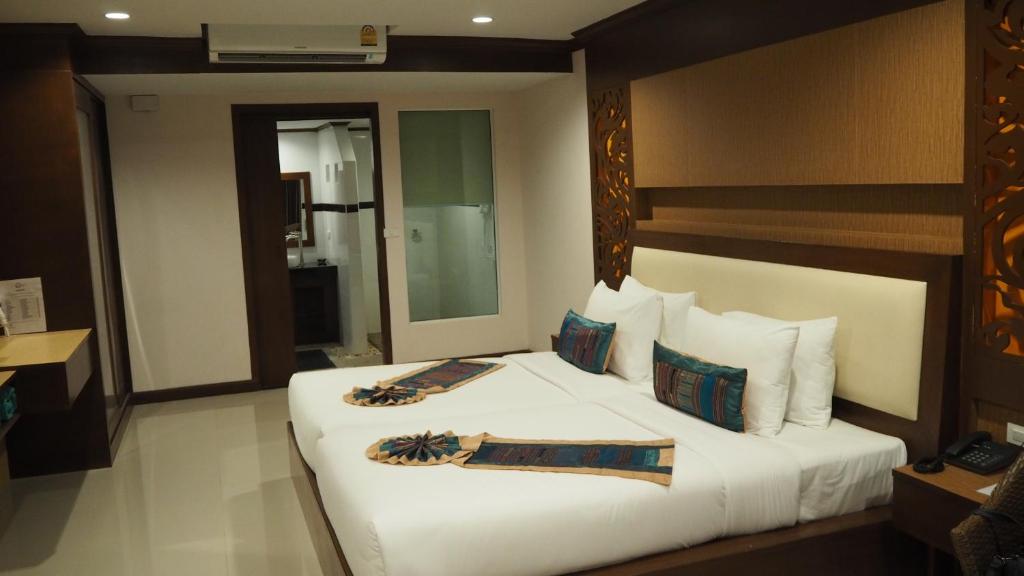 Mūsdienīgs numurs Chivatara Resort Bangtao ar divām gultām un vannas istabu.