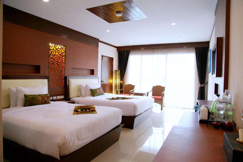 Modernais numurs Chivatara Resort Bangtao ar divām gultām un skatu uz dabu.