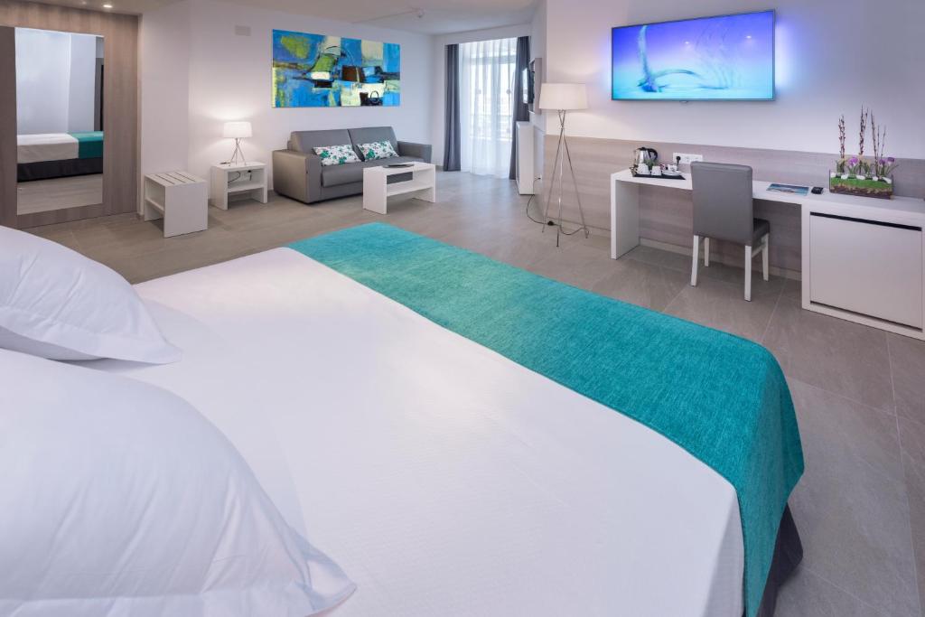 Mūsdienīgs viesnīcas numurs ar ērtu gultu, dīvānu un darba vietu, kas nodrošina komfortu un relaksāciju. Interjers ir gaišs un stilīgs, ar krāsainām mākslas gleznām un mūsdienīgu aprīkojumu.