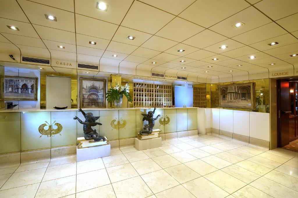 Luksusa viesnīcas reģistratūra ar elegantu interjeru, rotāta ar skulptūrām un gleznām. Gaismas un stikla elementi rada modernu un viesmīlīgu atmosfēru.