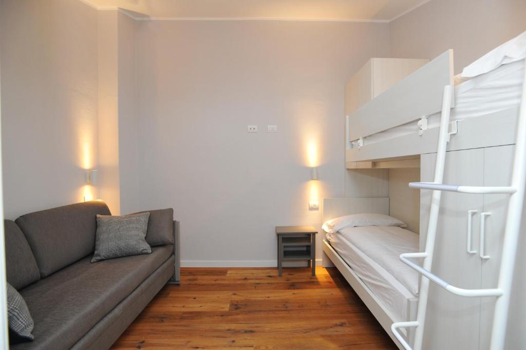 Mūsdienīgs viesnīcu numurs ar divstāvu gultu, dīvānu un koka grīdām, nodrošinot komfortablu un mājīgu atmosfēru. Ideāli piemērots ģimenēm vai grupām.