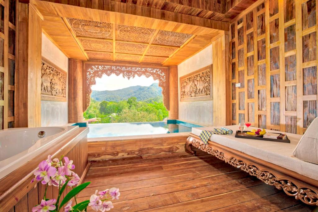 Elegants un mūsdienīgs interjers ar koka apdari un skatu uz kalniem, kas ietver vannu un atpūtas zonu. Telpa ir dekorēta ar ziediem un piedāvā relaksējošu atmosfēru.