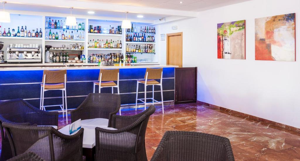 Mūsdienīgs bārs ar plašu alkohola izvēli un mājīgu sēdvietu zonu. Interjerā redzami stilīgi mākslas darbi un gaišs apgaismojums.