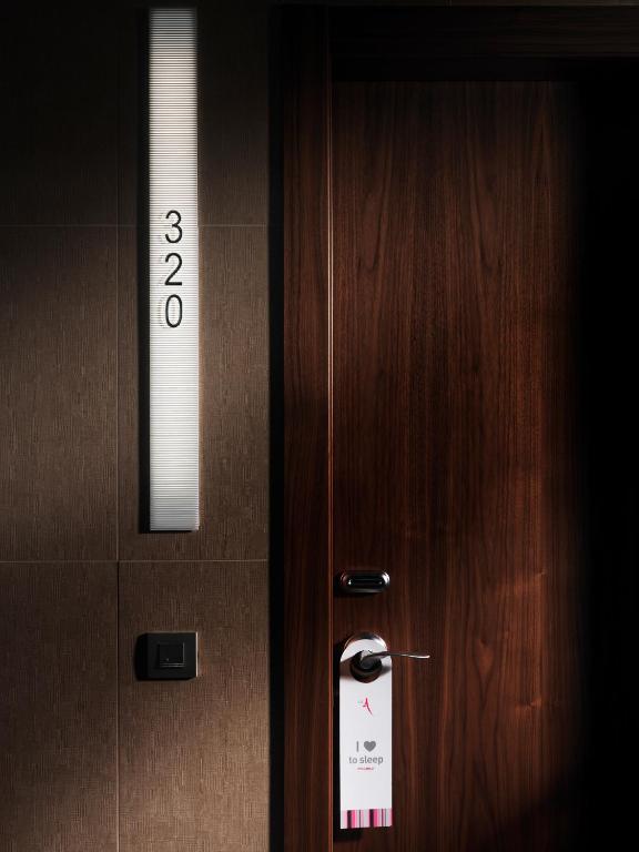 Durvis ar numuru 320 un plakātu "I love to sleep", kas piekārts pie roktura. Interjers ar tumšu koka apdari un modernu apgaismojumu.