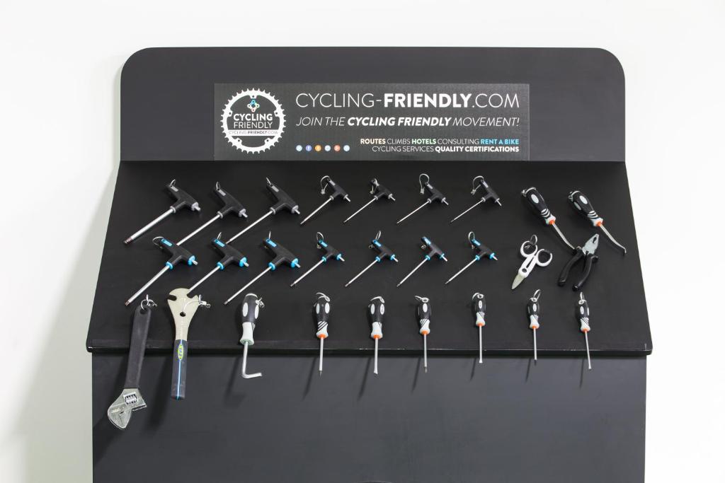 Rīku kolekcija, kas parāda dažādus velosipēdu apkalpošanas instrumentus uz melna fona ar "Cycling Friendly" logotipu. Ideāli piemērots velosipēdu entuziastiem un servisa darbiniekiem.