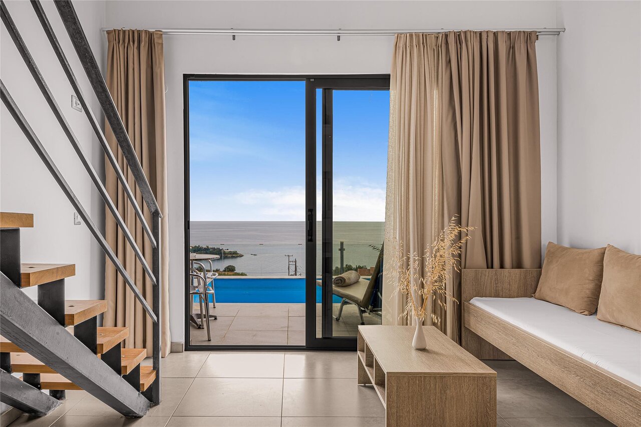 Panorama Village Hotel divlīmeņu numurs ar izeju uz privāto baseinu un skatu uz piekrasti.