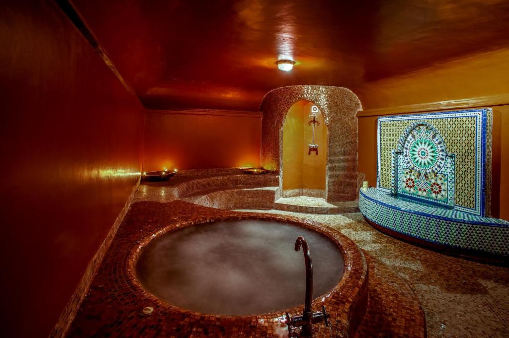 Relaksējoša un grezna spa telpa ar krāsainām flīzēm, burbuļvannu un dekoratīvu strūklaku, kas rada mierīgu atmosfēru. Ideāla vieta atpūtai un atjaunošanai.
