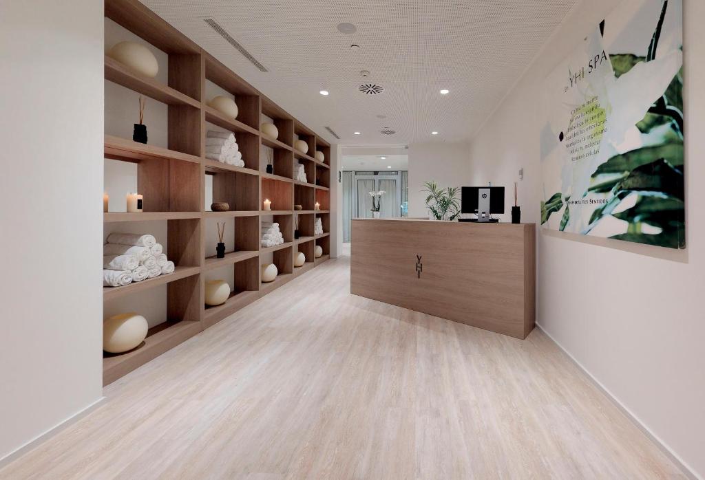 Moderns spa interjers ar koka plauktiem, uz kuriem novietoti dvieļi un sveces, veido relaksējošu atmosfēru. Reģistratūra ir izgaismota ar dabīgiem toņiem un zaļām dekorācijām.