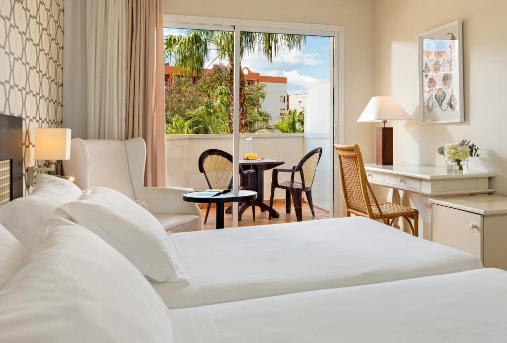 Mūsdienīgs viesnīcas numurs ar divām gultām, balkonu un skatu uz palmu dārzu. Telpā ir ērti mēbeles, ieskaitot rakstāmgaldu un krēslu, radot relaksējošu atmosfēru.