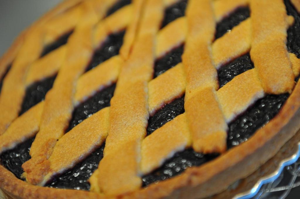 Melleņu pīrāgs ar zeltainu smalkmaizītes virskārtu, izveidots ar rakstainu režģi. Pīrāgs ir bagātīgi piepildīts ar sulīgu melleņu pildījumu, kas padara to par lielisku desertu.