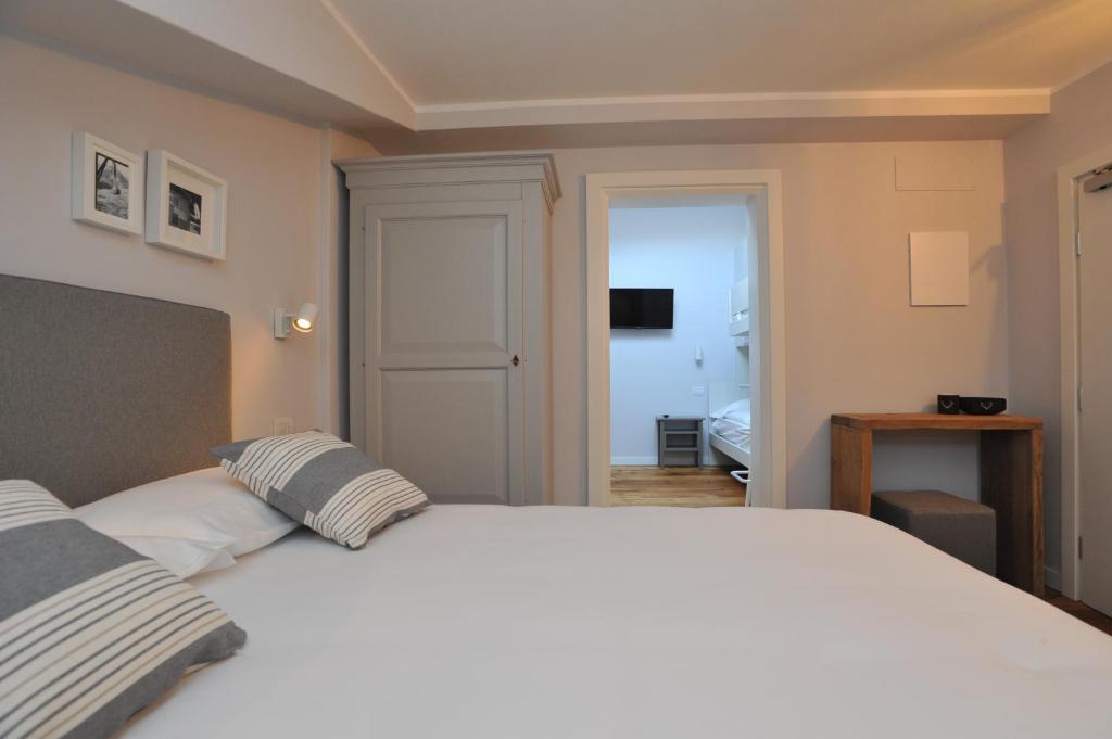 Mūsdienīgs guļamistabas interjers ar ērtu gultu un skatu uz blakus telpām. Telpā ir neitrālas krāsas un minimālistiski dekori.